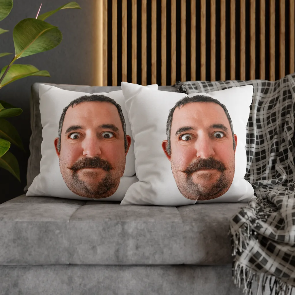 Two square cushions on a sofa, our picture printed across the face of each.